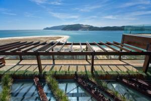 uma vista para a praia a partir da varanda de um resort em Aqualuz Troia Rio by The Editory em Troia