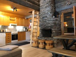 - une cuisine avec une cheminée en pierre et une table dans l'établissement Kuusiruka, à Ruka