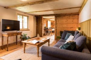 a living room with a couch and a table at WÄLDER: Quartier Dachsberg in Dachsberg im Schwarzwald