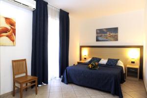 a bedroom with a bed and a chair and a window at Hotel La Quercia in Valmontone +29 photos