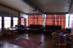 a waiting room with couches and tables and curtains at Mehamn Arctic Hotel in Mehamn