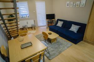 a living room with a blue couch and a table at Košuta 21 Center Duplex Apartment, Brzeće in Brzeće