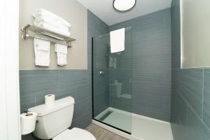 a bathroom with a toilet and a glass shower at Hollywood Palms Inns & Suites in Los Angeles
