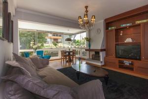 uma sala de estar com um sofá e uma televisão em Bosque de Astúrias 106 em Gramado