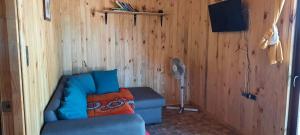 a living room with a blue couch and a fan at La Maravilla Lodge in Vilches