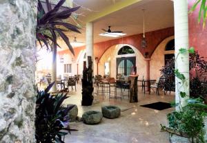 a lobby with tables and chairs in a building at Hacienda Hotel Santo Domingo in Izamal