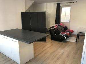 a kitchen with a black counter and a couch at Appartement centre ville in Dole