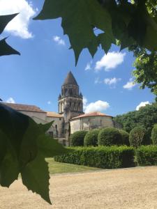 un ancien bâtiment avec une tour dans un jardin dans l'établissement La Vieille Distillerie, à Matha