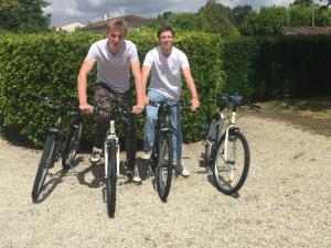 two men are posing with their bikes at La Vieille Distillerie in Matha