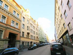 a street with cars parked on the sides of buildings at Roost Pursimiehenkatu in Helsinki