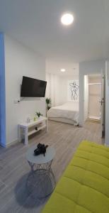 a living room with a bed and a tv and a table at Apartamento de 2020 a estrenar en pleno centro1B in Algeciras