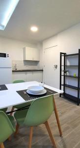 a kitchen with a table with green chairs in it at Apartamento de 2020 a estrenar en pleno centro1B in Algeciras