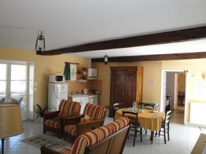 ein Wohnzimmer mit einem Tisch und Stühlen sowie eine Küche in der Unterkunft Ferme de La poterie in Donnery