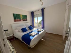 a bedroom with a bed with blue pillows and a window at Apartment Llavaneres II in Sant Andreu de Llavaneres +22 photos
