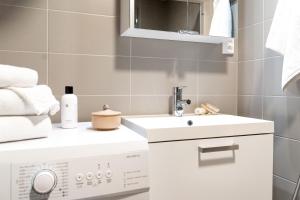 een badkamer met een wastafel en een wasmachine bij Roost Logomo in Turku