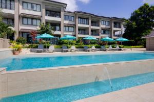 una piscina en un hotel con sillas y sombrillas en Beach View Hotel en Saint James