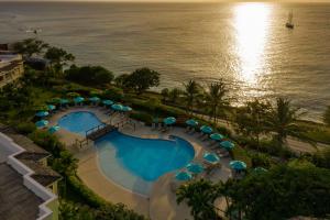 an overhead view of a swimming pool with umbrellas and the ocean at Beach View Hotel in Saint James