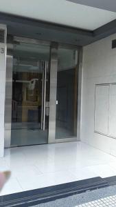 una gran puerta de cristal en un edificio con suelo blanco en AiresSoho1633 en Buenos Aires