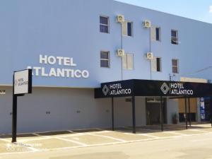 um hotel com uma placa em frente a um edifício em Hotel Atlântico em Americana