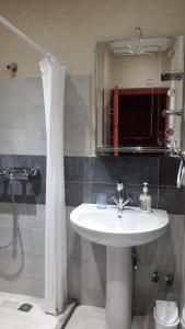 La salle de bains est pourvue d'un lavabo et d'une douche avec un miroir. dans l'établissement Le Chêne d´Azrou, à Azrou