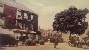 una mujer caminando por una calle con un carruaje tirado por caballos en The Beach Hotel, en Minehead