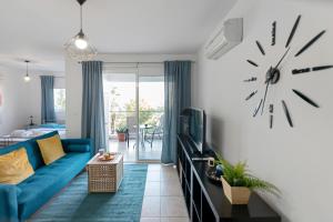 sala de estar con sofá azul y reloj en la pared en Glabur Stays - The Cozy Atelier - Nicosia City, Free Parking & Wifi, Welcomes You!!!, en Nicosia