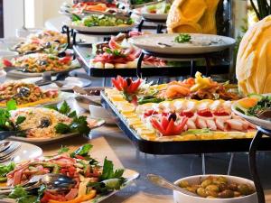 un buffet con muchos platos de comida en una mesa en Grand Milano Hotel, en Ayvalık