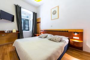 a bedroom with a bed with two pillows on it at Kaboga street Rooms in Dubrovnik