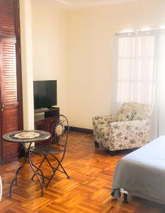 1 dormitorio con 1 cama, 1 silla y 1 mesa en Ester`s Place en Escazú