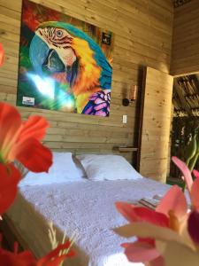 Glamping Paihuen في فيلافيسينسيو: غرفة نوم فيها لوحة طاووس على الحائط