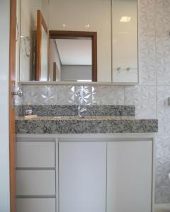 y baño con lavabo y espejo. en Terra Home Suítes 2 - Hospedagens de alto padrão em Piumhi MG, en Piauí