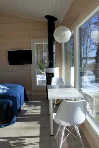 1 dormitorio con 1 cama, mesa blanca y sillas en Pikkumerikotka, en Kustavi