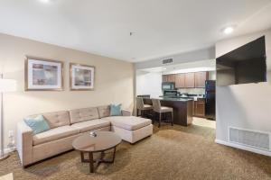 a living room with a couch and a kitchen at Chase Suites Brea-Fullerton - North Orange County in Brea