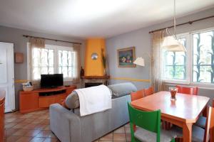 een woonkamer met een bank en een tafel bij La Casa del Bosc, playa y golf - Salou in Salou