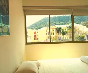 a bedroom with a window with a view of a building at Hotel Doral in Panama City