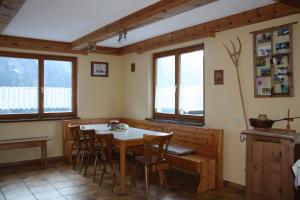 Haus Martine في Raggal: غرفة طعام مع طاولة وكراسي ونوافذ