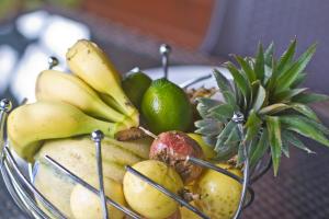 a bowl of fruit with bananas and limes on a table at Gwada Dream in Sainte-Anne