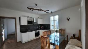 kuchnia ze szklanym stołem w pokoju w obiekcie Apartmán Janské lázně w Jańskich Łaźniach