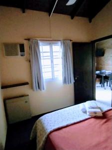 a bedroom with a bed and a window at Portal del Sur in Chascomús
