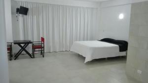 1 dormitorio con cama, escritorio y mesa en Costanera Estudio en Santa Clara del Mar