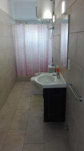 baño con lavabo y cortina de ducha rosa en Costanera Estudio en Santa Clara del Mar
