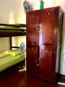 a large wooden cabinet next to a bunk bed at Casa Lula León Hostal in León