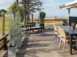 une terrasse avec une table et des chaises et l'océan dans l'établissement 6 person holiday home in Nordborg, à Nordborg