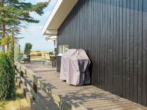 ノーポにある6 person holiday home in Nordborgの木製デッキ(テーブル、椅子付)