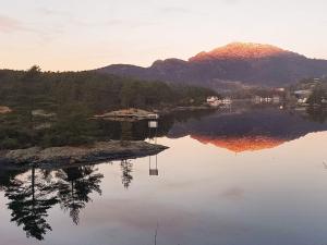 a reflection of a mountain in a body of water at Tranquil Retreat in Moster-By Traum in Mosterhamn