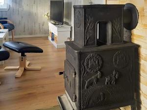 a black wood stove in a room with a stool at Tranquil Retreat in Moster-By Traum in Mosterhamn