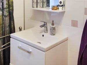 ein Badezimmer mit einem weißen Waschbecken und einem Spiegel in der Unterkunft 6 person holiday home in MOSTERHAMN in Mosterhamn