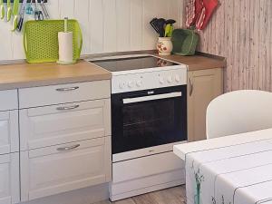 eine Küche mit einem weißen Herd oberer Ofen neben einer Theke in der Unterkunft 6 person holiday home in MOSTERHAMN in Mosterhamn