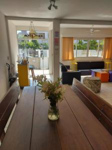 una sala de estar con una mesa de madera con flores. en Eco Isla GuestHouse, en Florianópolis