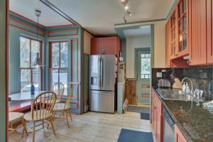 a kitchen with a refrigerator and a table and chairs at Historic Breck Cabin with Hot Tub Walk to Main St! in Breckenridge